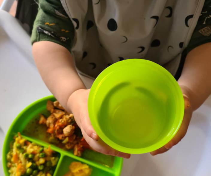 Child holding a green cup