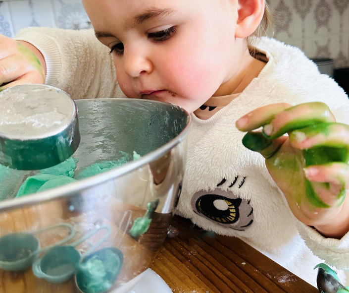 The child is making blue playdough